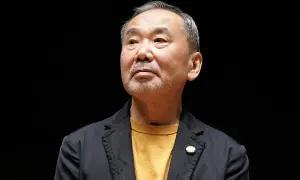 Haruki Murakami, autor de frases memorables, mira hacia arriba con una expresión pensativa.