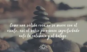 Piedras apiladas con frases budistas: "Como una sólida roca no se mueve con el viento, así el sabio permanece imperturbado ante la calumnia y el halago.