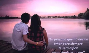 Pareja abraza en muelle al atardecer. La frase "existe el amor para toda la vida" inspira, sugiriendo que la decisión de amar siempre es clave.