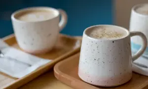 Dos tazas de café con leche espumosa, un recordatorio de los beneficios de dejar el café.
