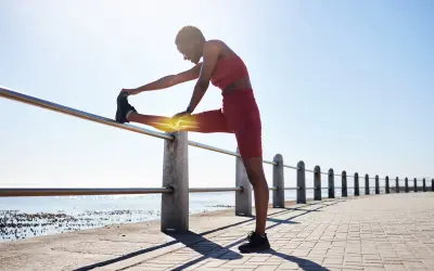 Mujer estirando la pierna en una barandilla, sintiendo la **necesidad de control** sobre su cuerpo y el dolor.