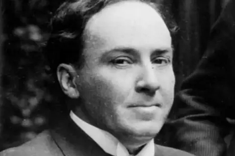 Retrato de un hombre con traje y corbata, evoca las profundas frases de Antonio Machado sobre el tiempo y la vida.