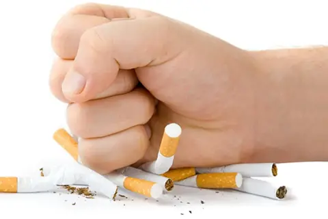 Puño aplastando cigarrillos. La lucha contra cuanto dura el mono del tabaco es posible.