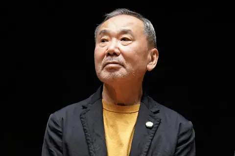 Haruki Murakami, autor de frases memorables, mira hacia arriba con una expresión pensativa.