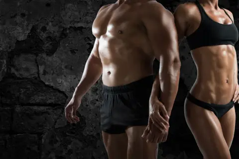 Pareja con cuerpos musculosos, reflejo de la obsesión por el físico, un ejemplo de qué es la vigorexia.