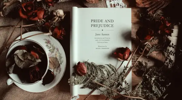 Un libro abierto de "Orgullo y Prejuicio" de Jane Austen, rodeado de rosas secas y helechos, evoca la atmósfera de sus obras.