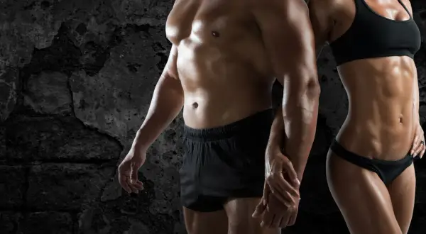 Pareja con cuerpos musculosos, reflejo de la obsesión por el físico, un ejemplo de qué es la vigorexia.