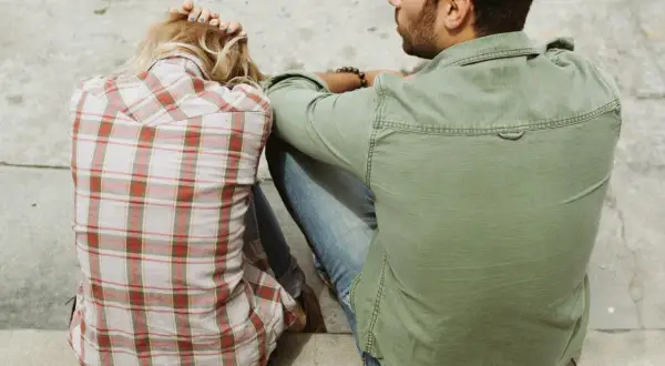 Pareja sentada, ella con la cabeza apoyada en las manos, él mirándola. Un momento íntimo, quizás el inicio de cómo liarse con alguien.
