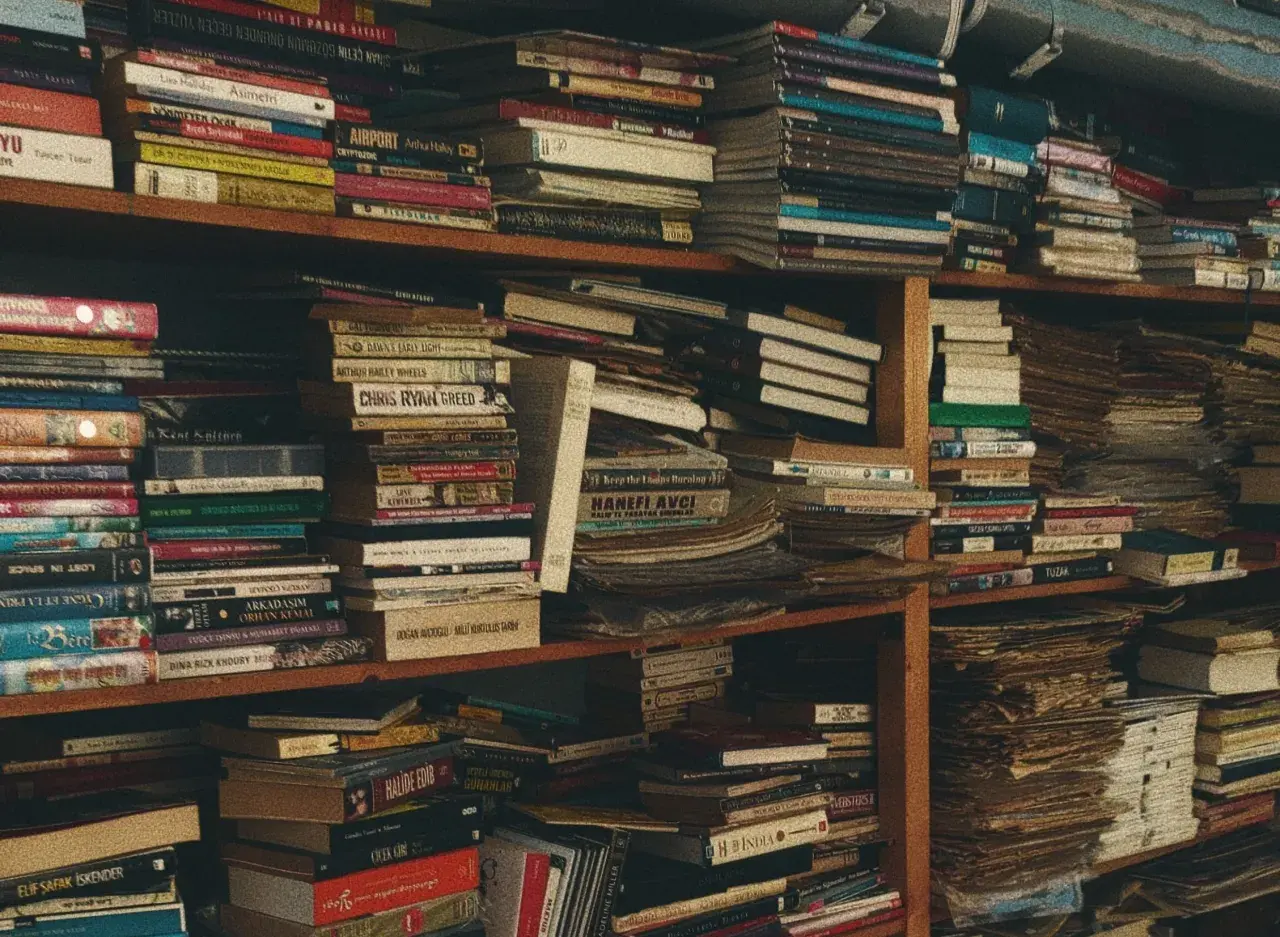 Estanterías repletas de libros, algunos con títulos sugerentes como "libros prohibidos", crean un laberinto de conocimiento y misterio.