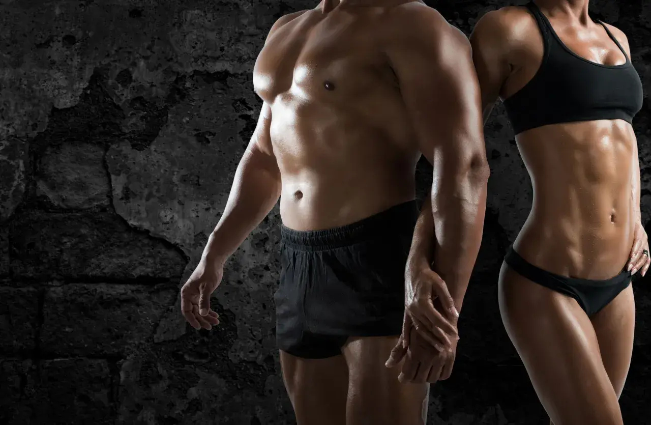 Pareja con cuerpos musculosos, reflejo de la obsesión por el físico, un ejemplo de qué es la vigorexia.