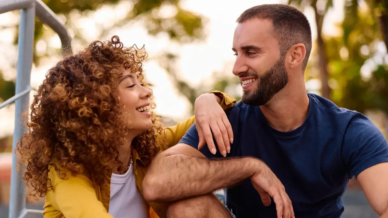 Una pareja r&iacute;e y se mira, &iquest;ser&aacute; que &eacute;l est&aacute; en la friend zone? Ella tiene el pelo rizado y &eacute;l barba.