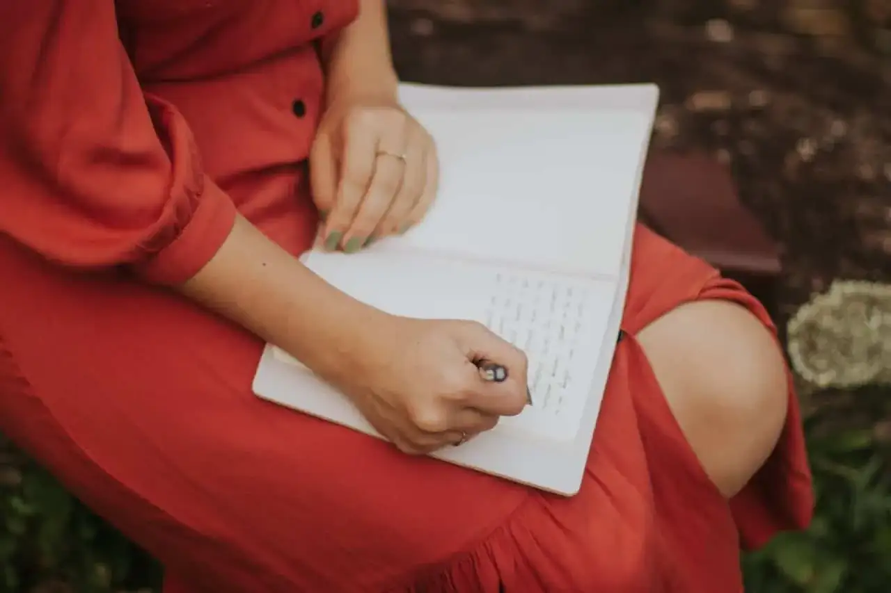 Persona escribiendo en un diario, reflejando sus valores. Ejemplos de reflexi&oacute;n personal.