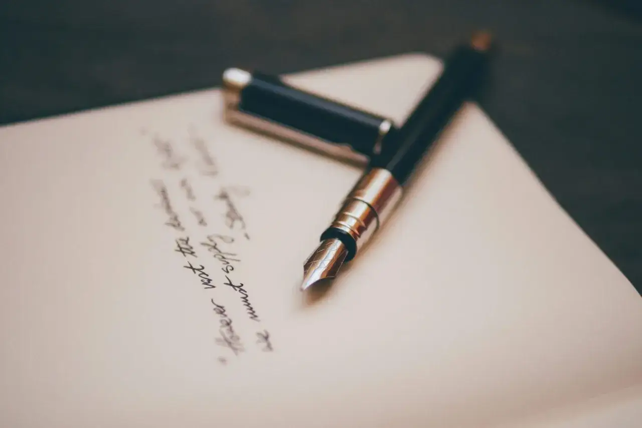 Pluma estilogr&aacute;fica sobre papel con escritura a mano. Ideal para encontrar frases bonitas para dedicar un libro y dejar tu huella.
