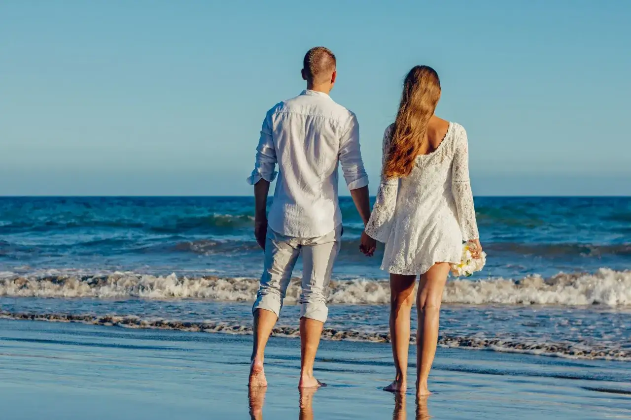 Pareja de espaldas en la playa, cogidos de la mano, contemplando el mar. &iquest;Ser&aacute; el inicio de una reconciliaci&oacute;n tras una crisis de pareja?