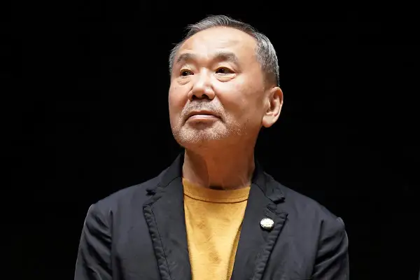 Haruki Murakami, autor de frases memorables, mira hacia arriba con una expresión pensativa.