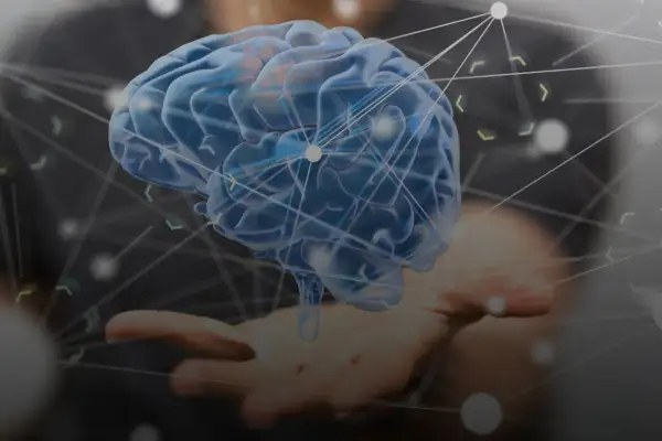 Cerebro azul translúcido sobre una mano, con una red de conexiones que representa las ramas de la psicología y el conocimiento.